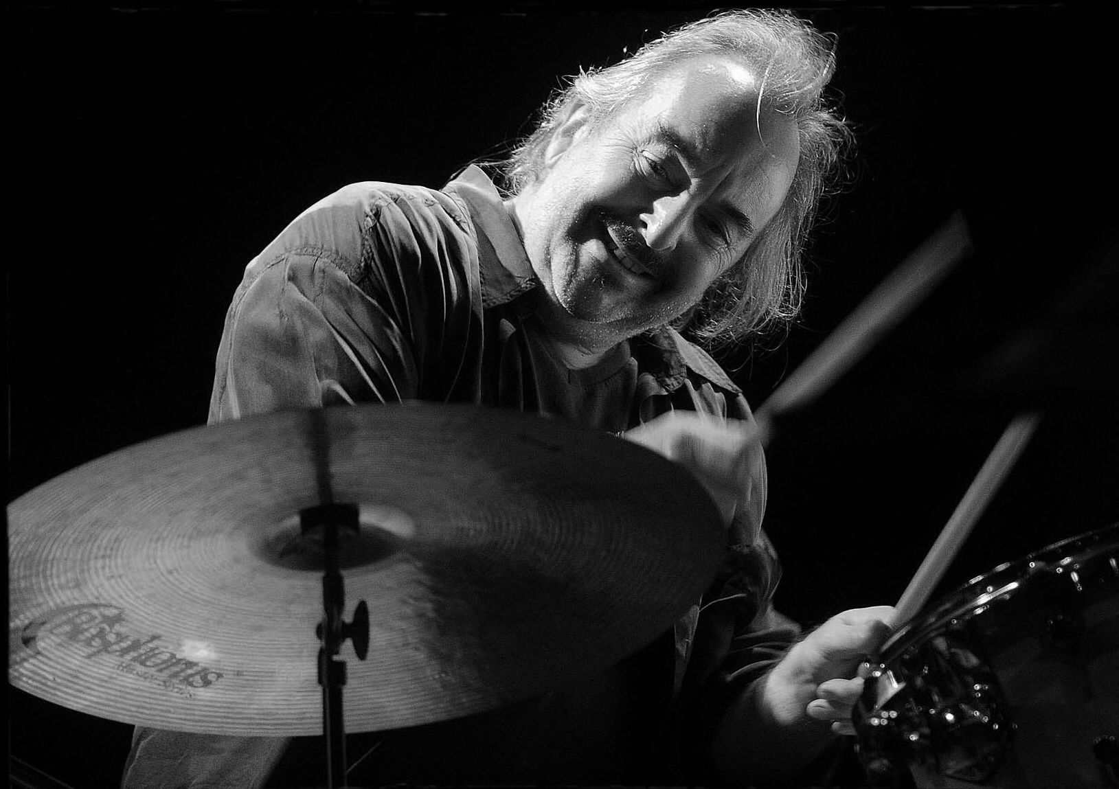 Luis Ceravolo playing the drums, smiling behind a ride cymbal