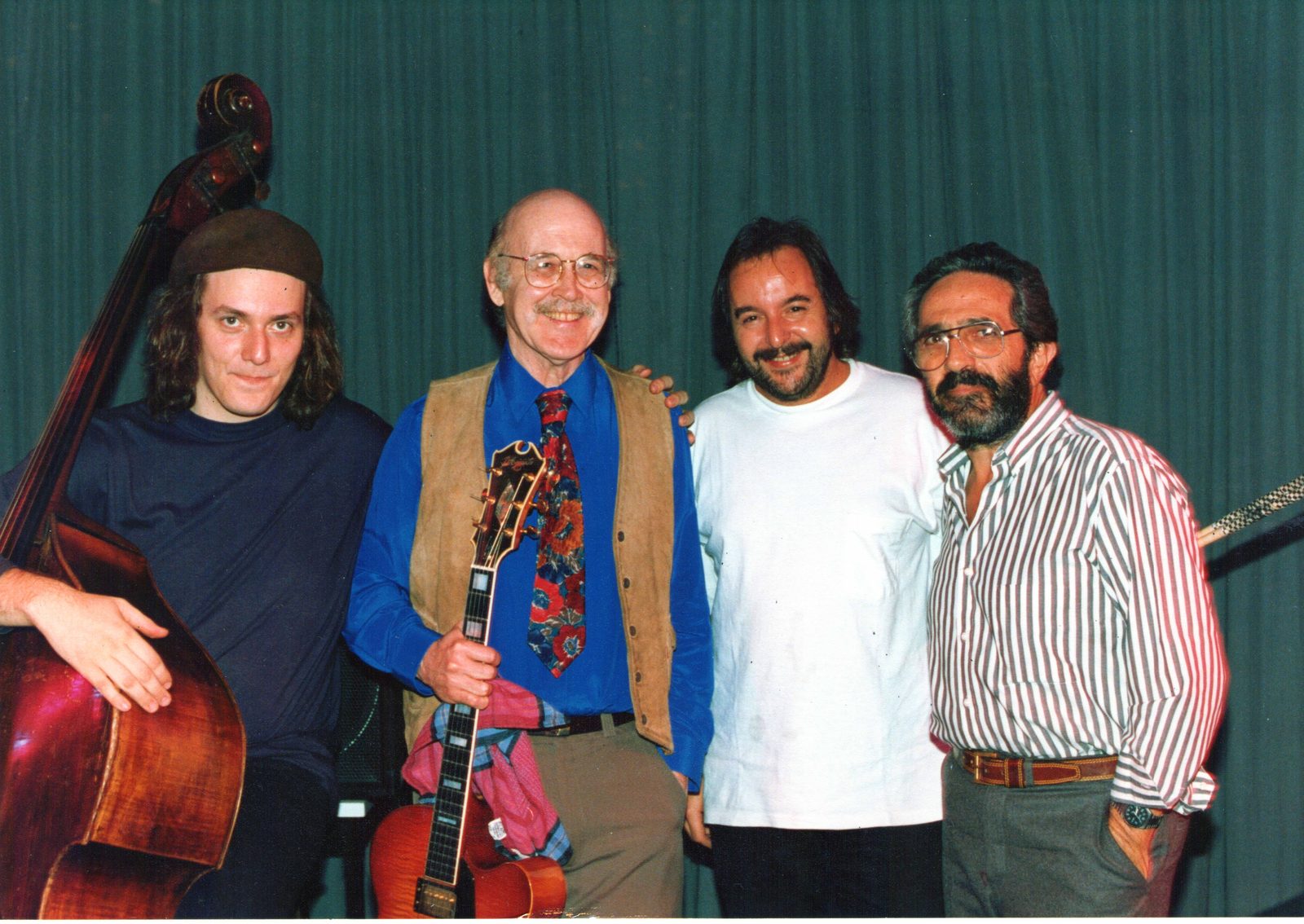 Javier Malosetti with a double bass, Jim Hall holding his guitar, Luis Ceravolo and Baby López Fürst, standing together in front of a green stage curtain at Teatro La Plaza, Buenos Aires, 1992